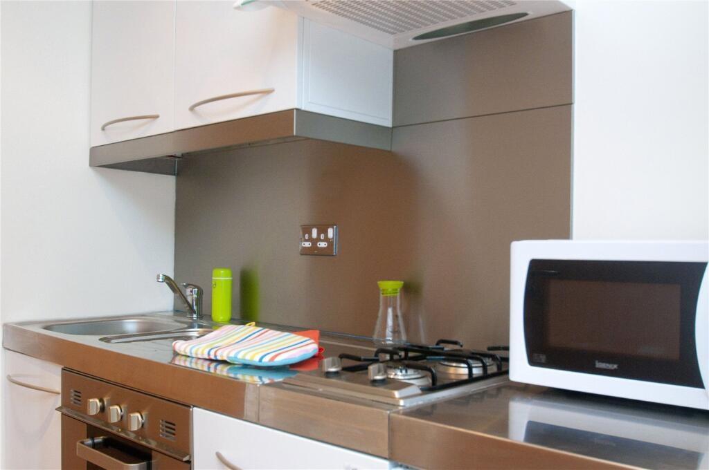 Modern kitchen area featuring a stainless steel...
