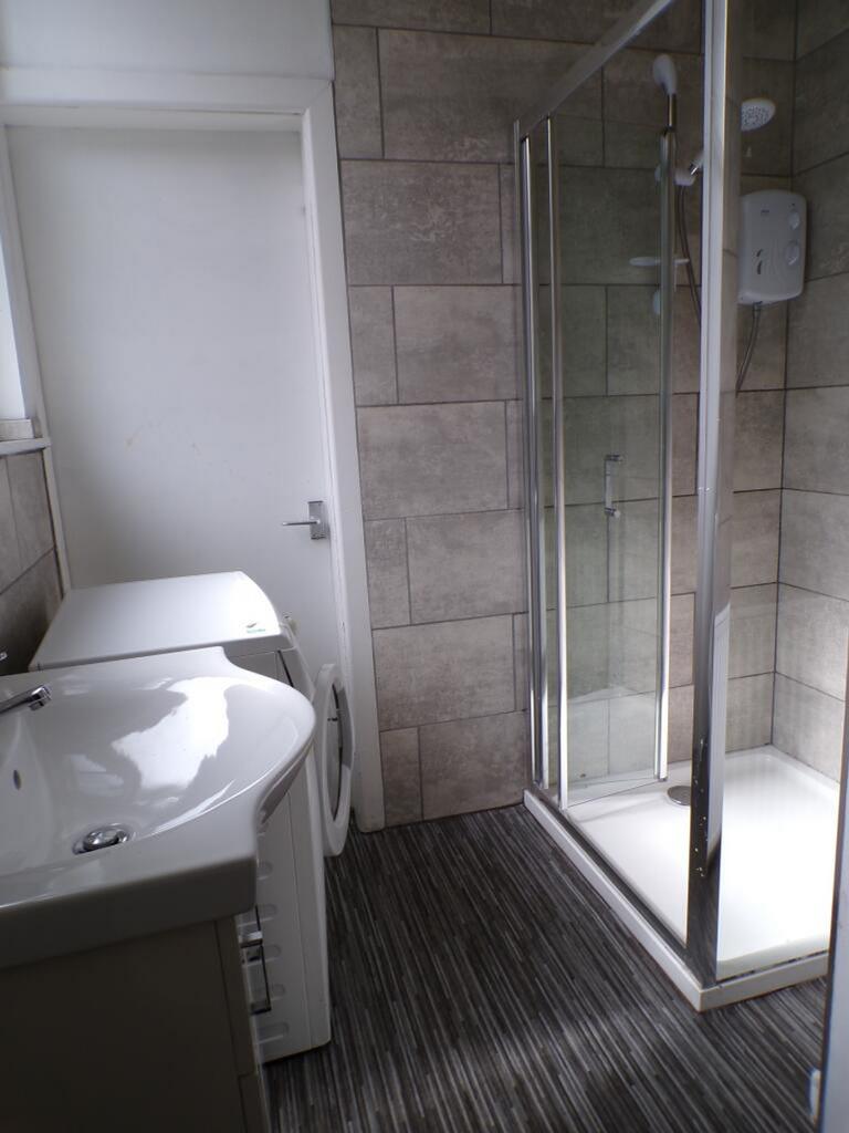 This modern bathroom features a spacious shower...
