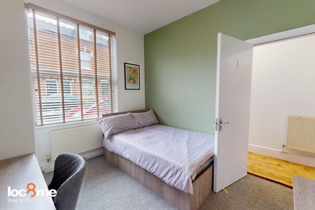 A bright and tidy double bedroom featuring mode...