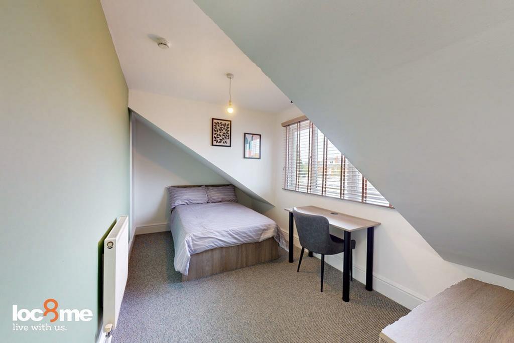 A cozy double bedroom with ample natural light,...