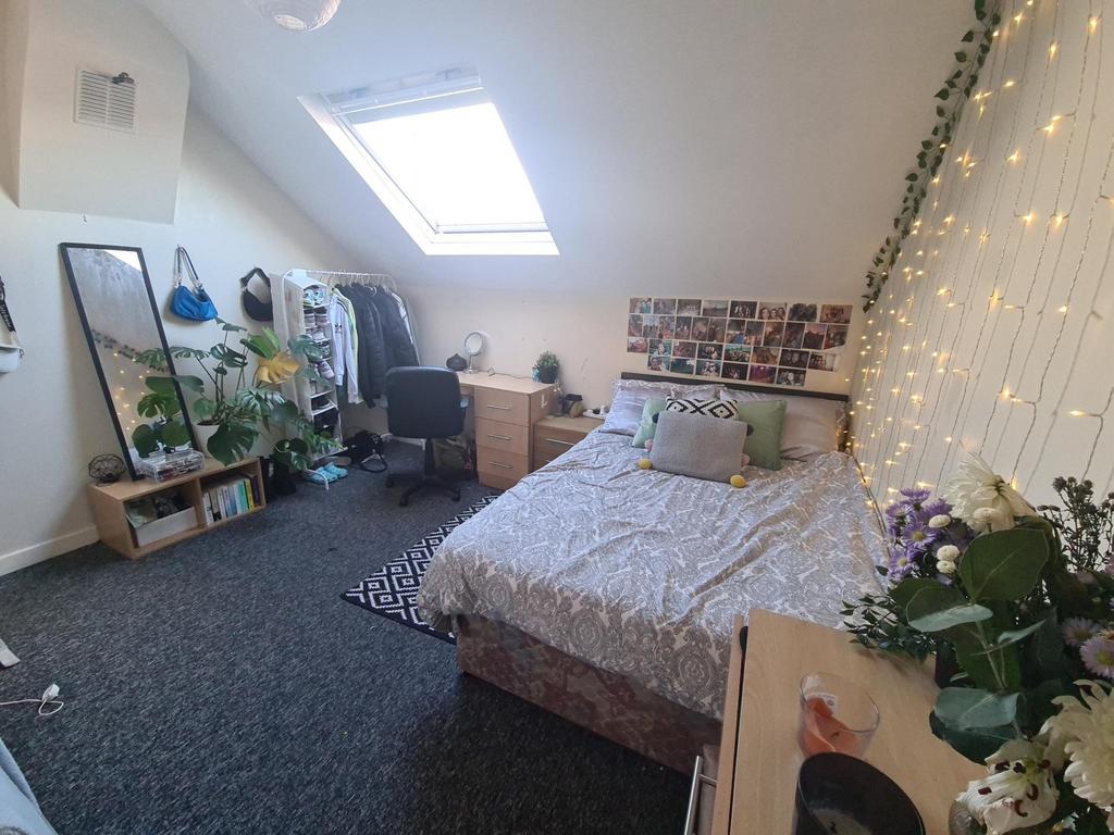 A cozy and well-lit bedroom featuring a double ...
