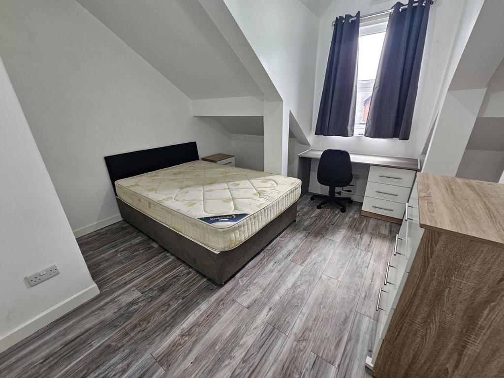 Bright and tidy bedroom featuring a comfortable...