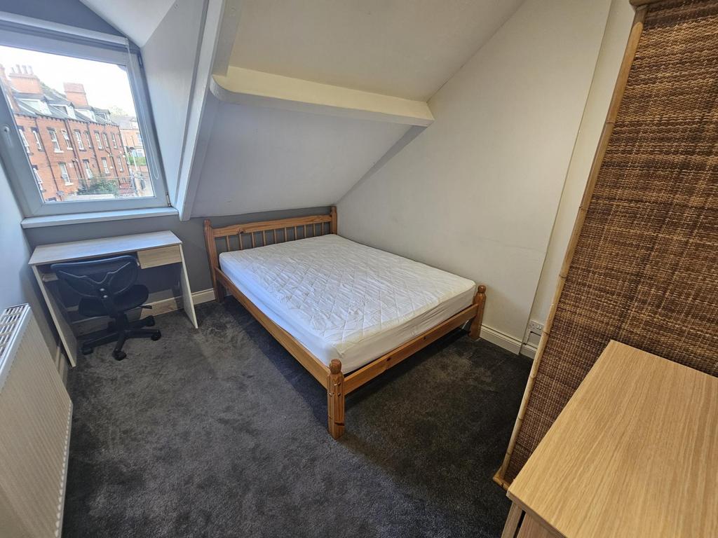 A cozy single bedroom featuring a comfortable b...