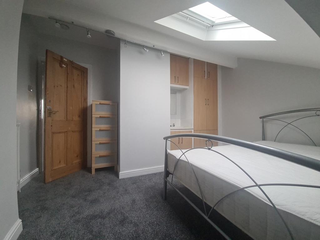 A bright and airy attic bedroom featuring a met...