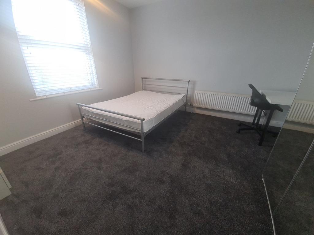 A simple, clean, well-lit bedroom with a single...