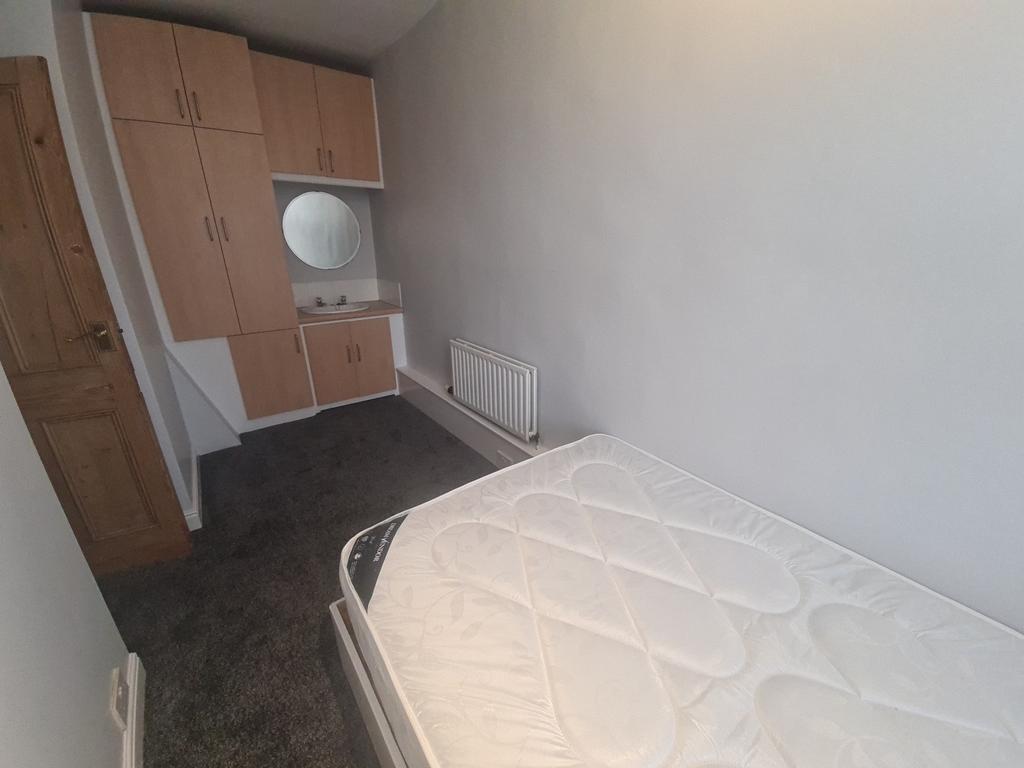 A modestly sized bedroom with a single bed and ...