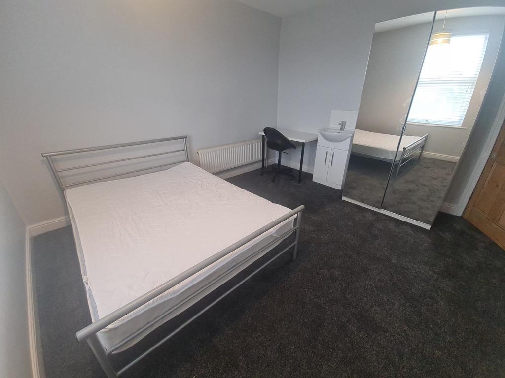 A tidy and straightforward bedroom featuring a ...