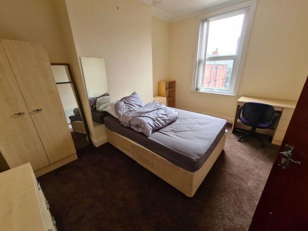 A cozy double bedroom with a neatly made bed, a...
