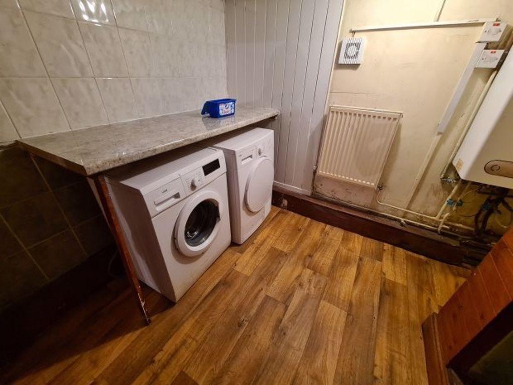 A functional laundry area featuring a washing m...