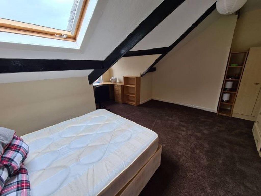 A cozy bedroom with a neatly made bed positione...