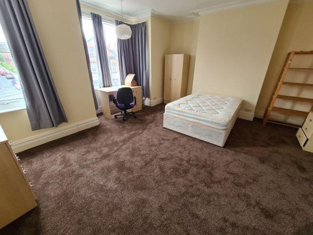 A modest single bedroom featuring a mattress, a...