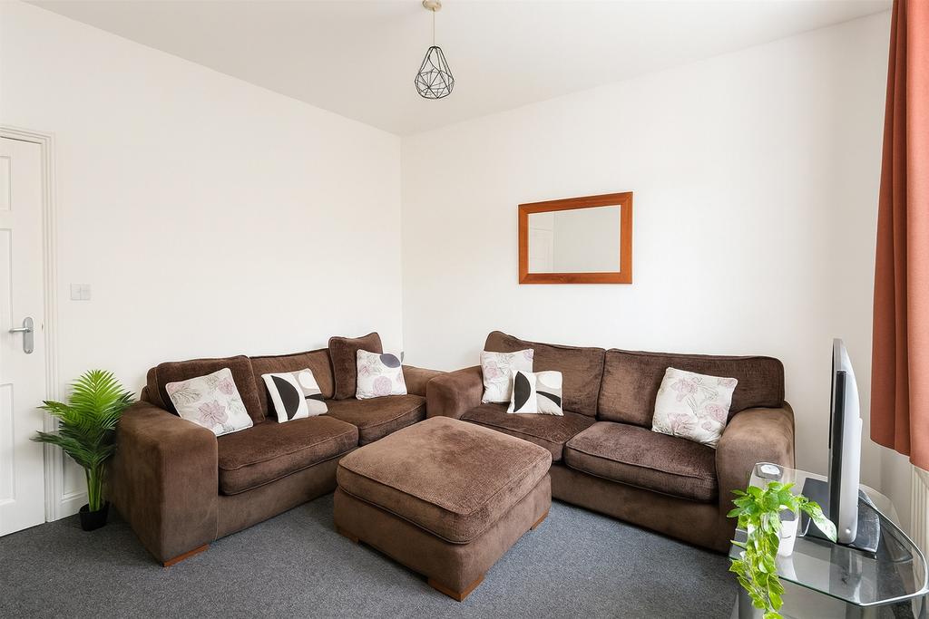 Bright, neatly presented living room with a lar...