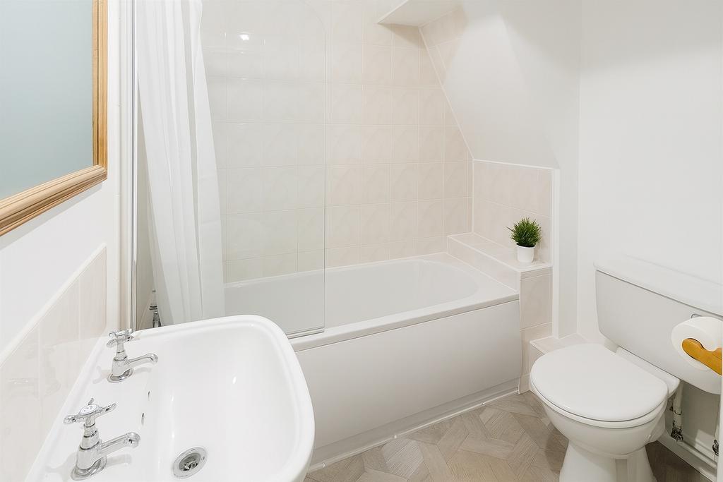 Bright, modern bathroom with a clean white bath...