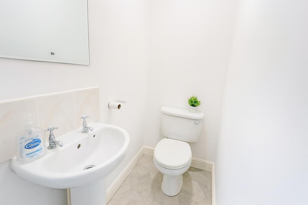 Bright, well‑kept WC with a clean pedestal sink...