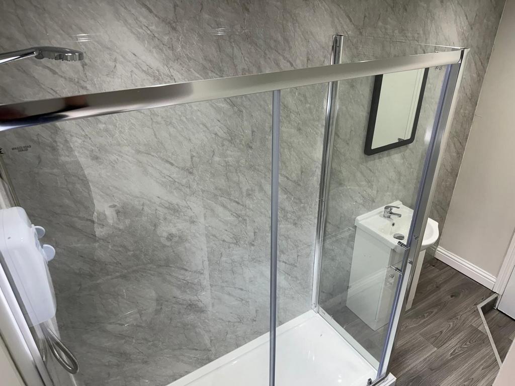 Modern bathroom featuring a sleek shower enclos...