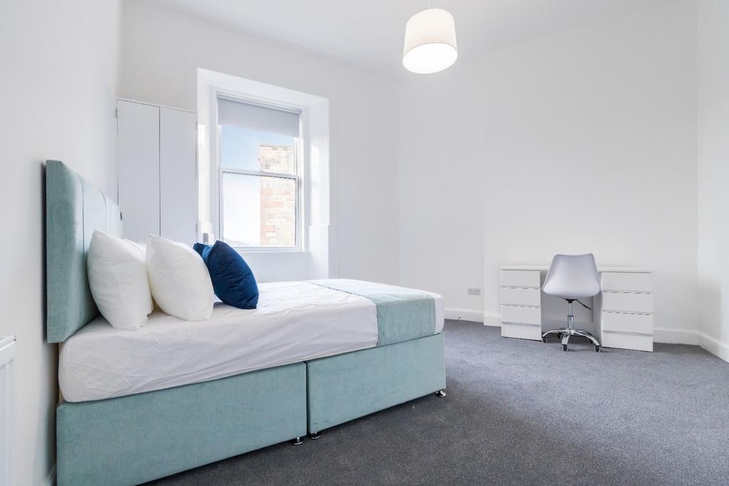 Spacious double bedroom featuring large windows...