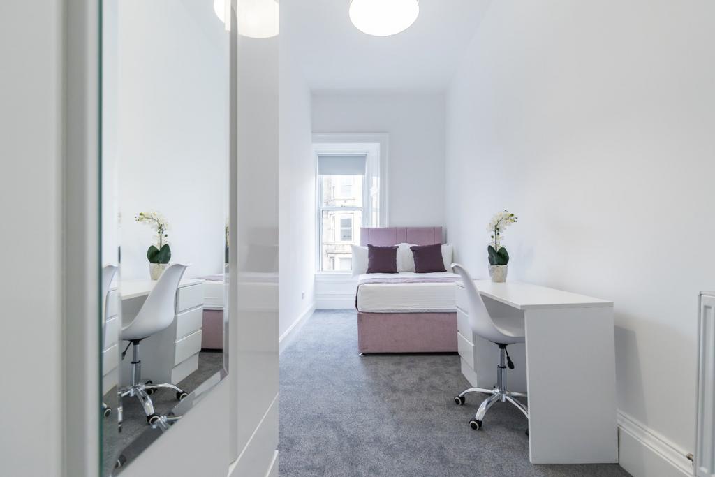 This cozy double bedroom features ample natural...