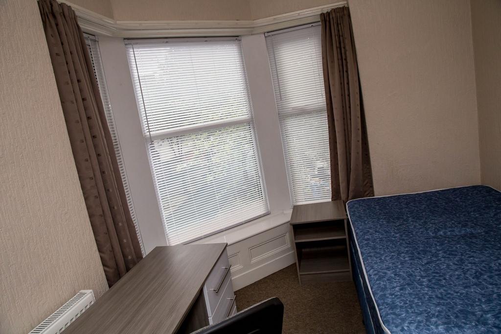 Spacious double bedroom featuring large windows...