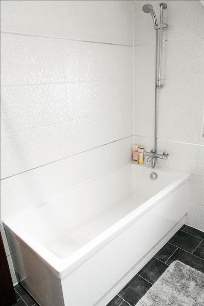 This modern bathroom features a sleek bathtub a...
