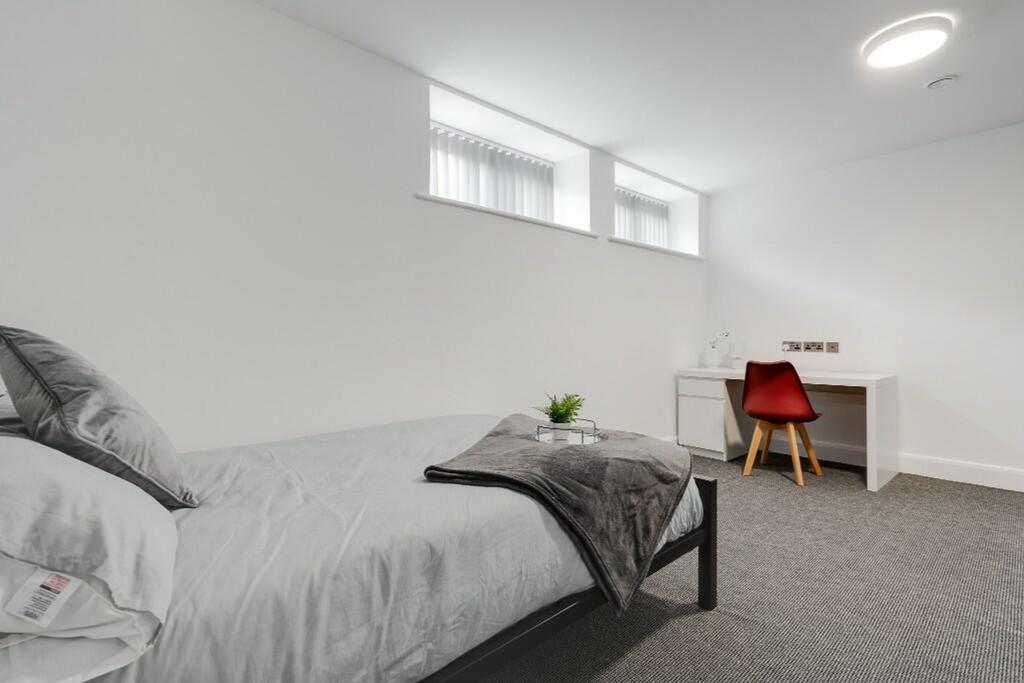 This stylish double bedroom features a cozy bed...
