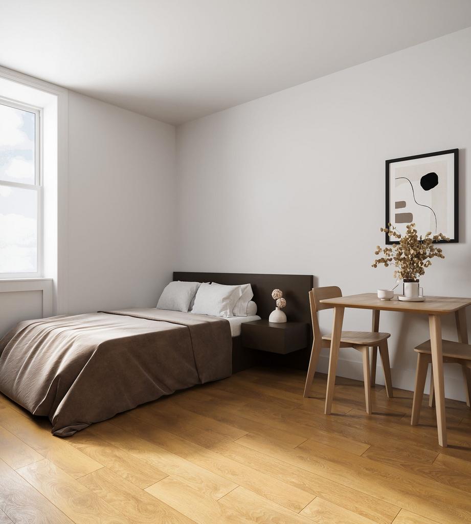 A tidy and well-lit double bedroom with wooden ...