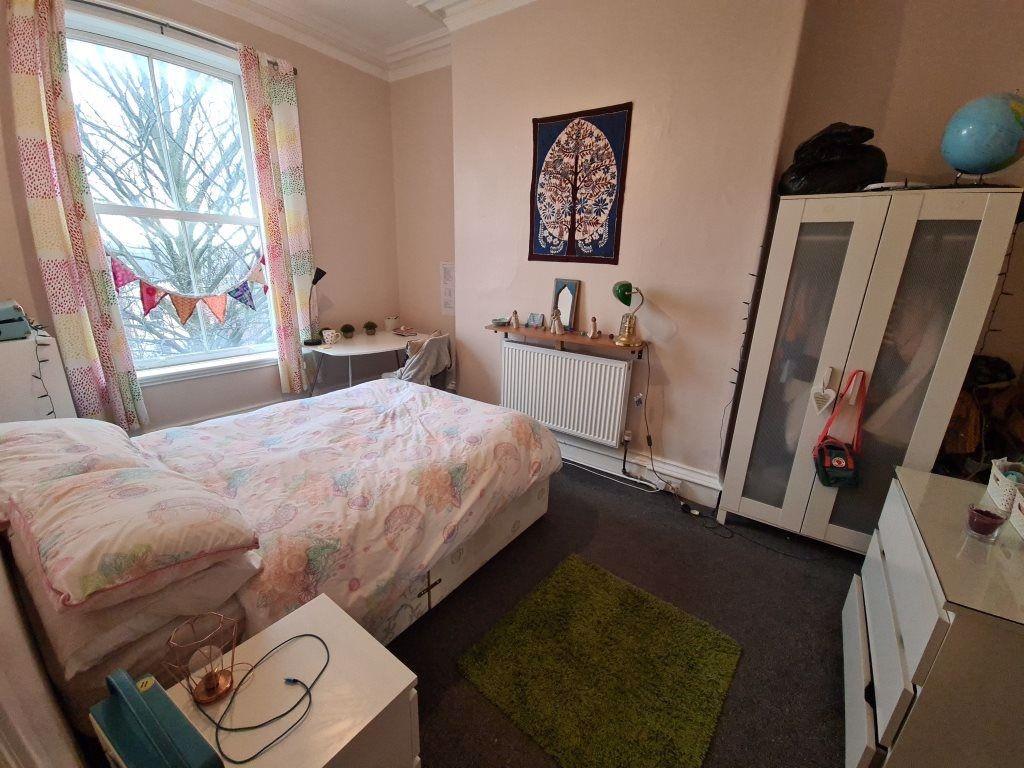A cozy double bedroom featuring a large window ...