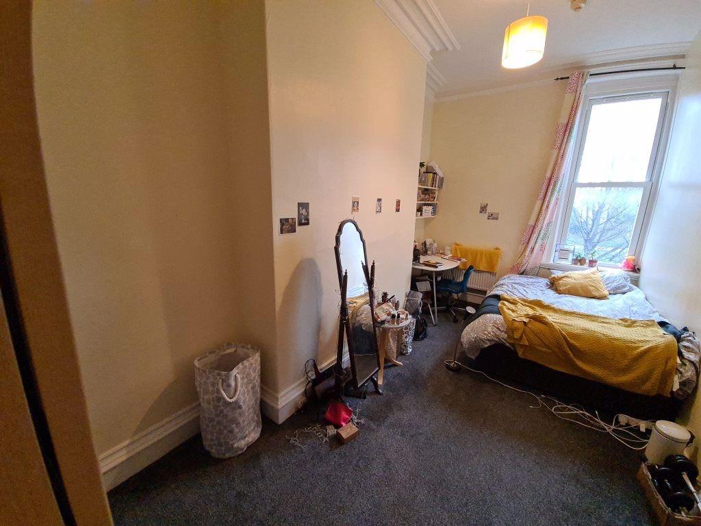 Cozy single bedroom featuring a comfortable bed...