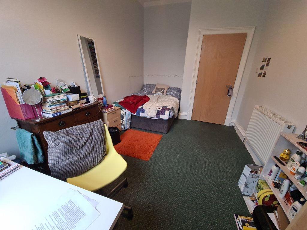 A cozy student bedroom featuring a single bed, ...