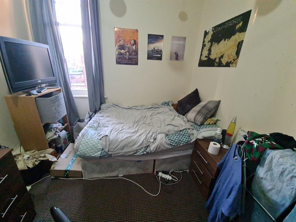 Cozy bedroom featuring a neatly made bed with s...