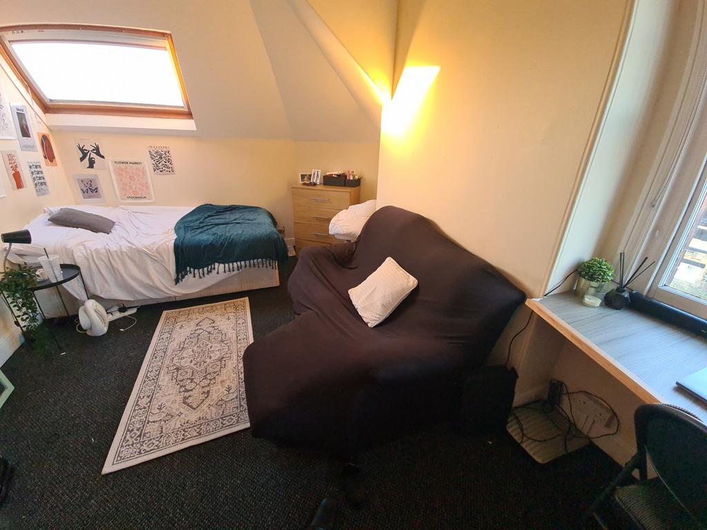 Cozy single bedroom featuring a comfortable bed...