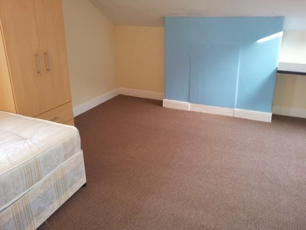 A neat and simple bedroom featuring a single be...