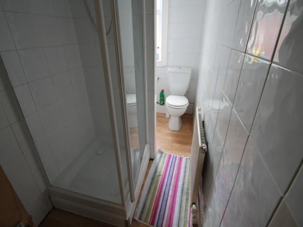 A compact, clean bathroom featuring a walk-in s...