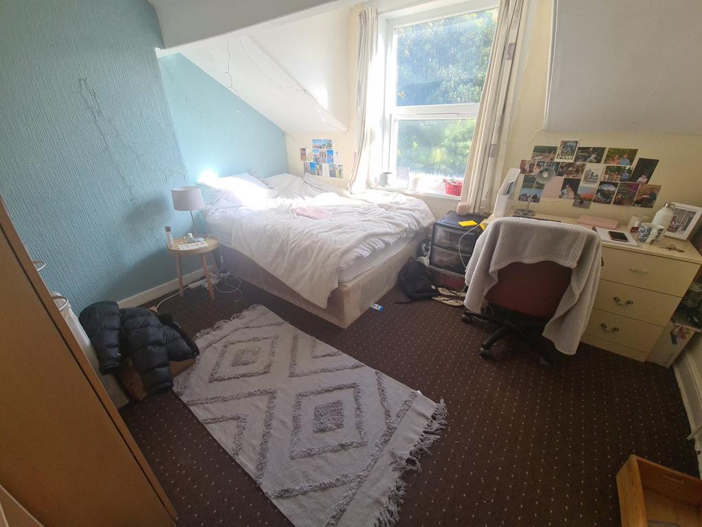 Cozy single bedroom with a large window providi...