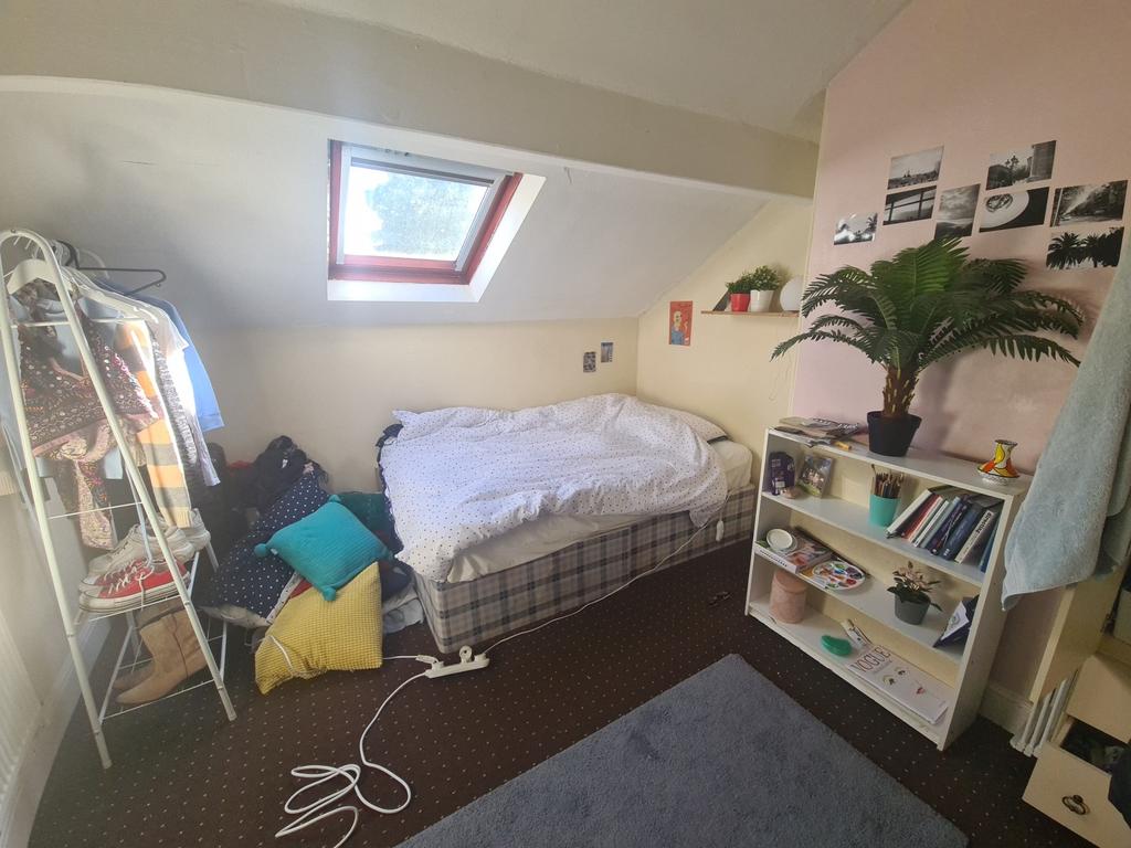 Cozy single bedroom with a skylight window prov...