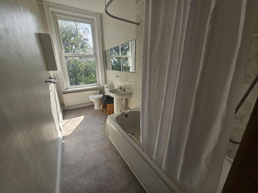 A well-maintained bathroom featuring a bathtub ...