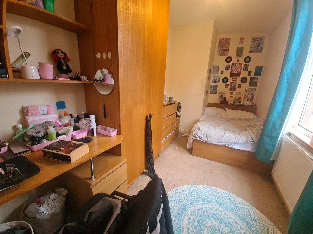 A cozy and well-organized single bedroom featur...