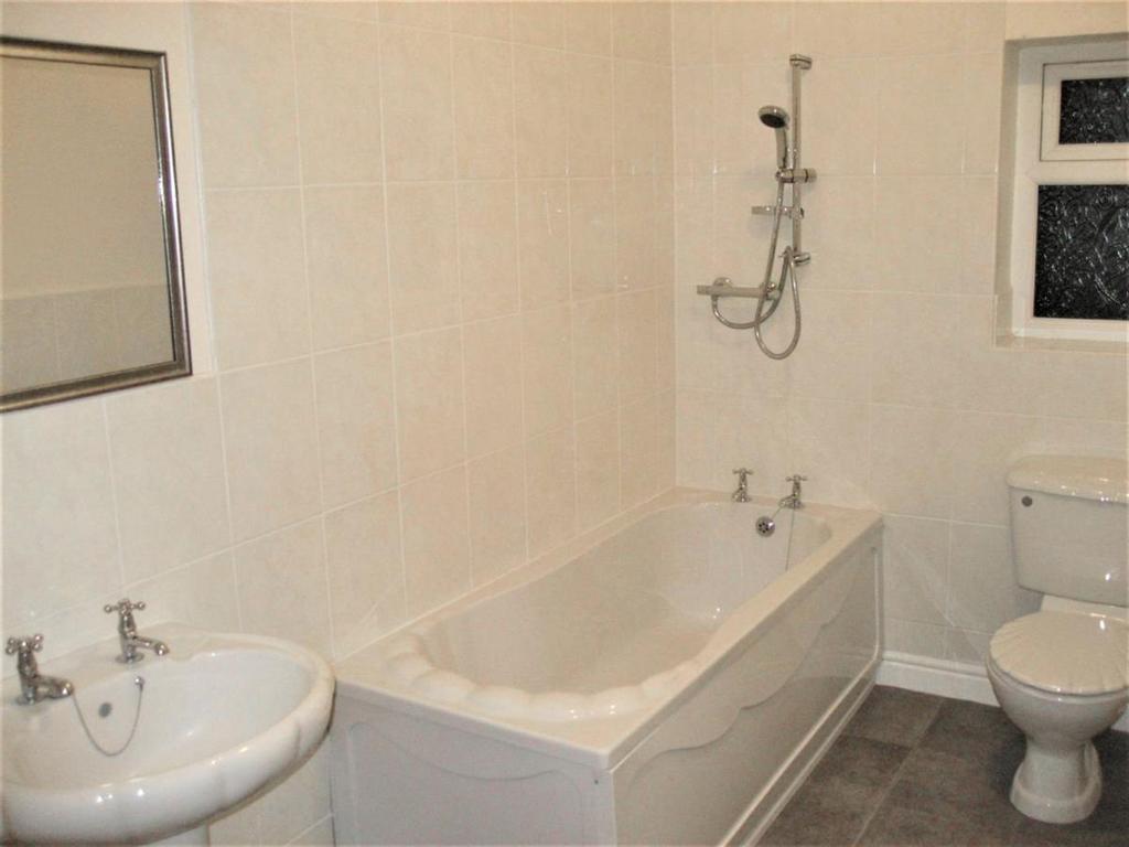 A bright and clean bathroom featuring a full-si...