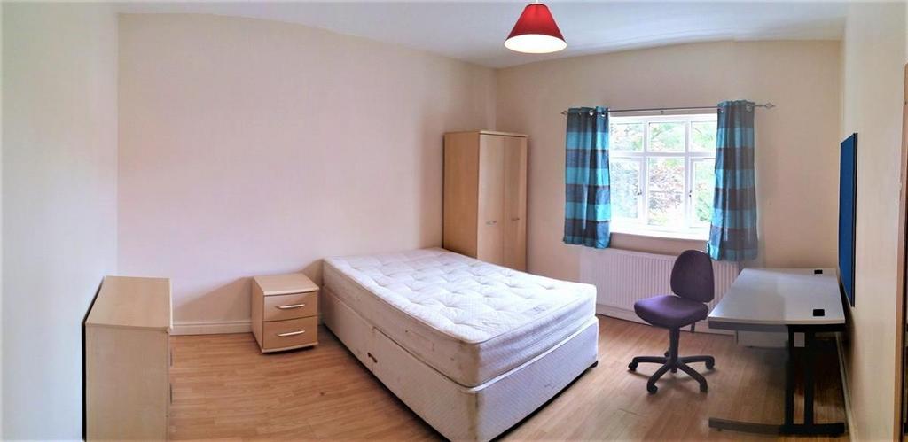 A bright and tidy master bedroom with a large w...