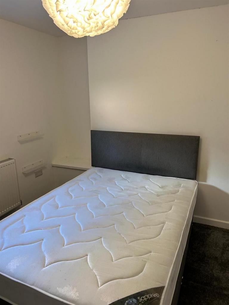 A neat and tidy single bedroom featuring a clea...