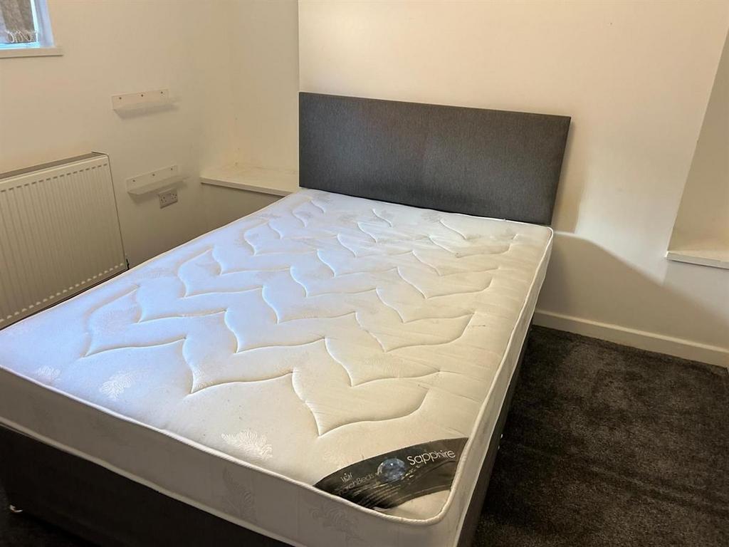 Neat double bedroom with a modern upholstered b...