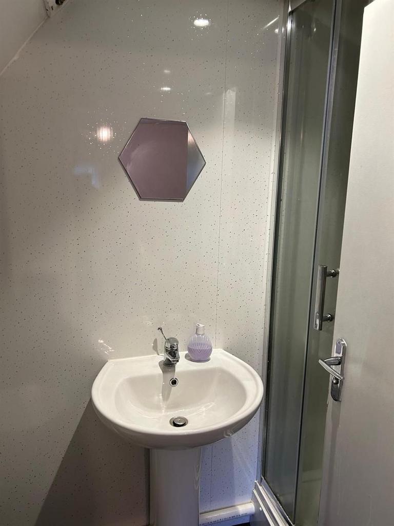 Compact, modern bathroom with a pedestal sink, ...