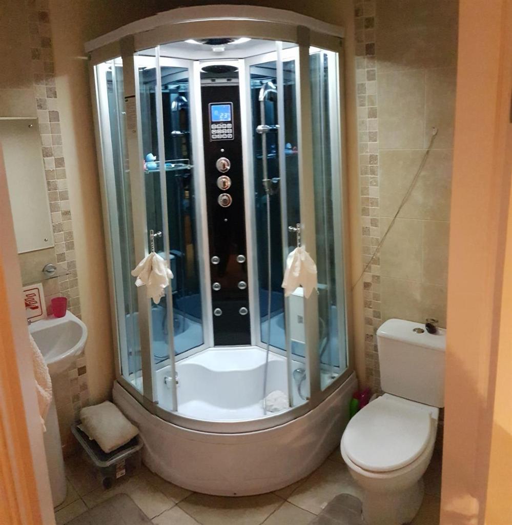 A modern bathroom featuring a compact shower ca...