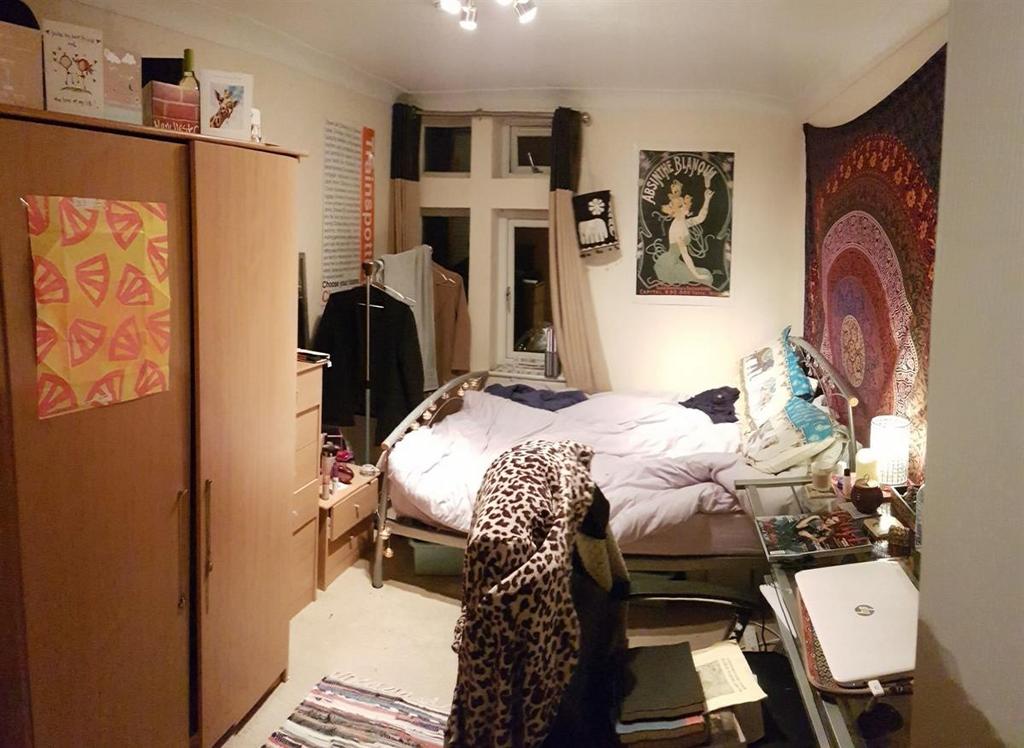 A cozy and personalized single bedroom featurin...