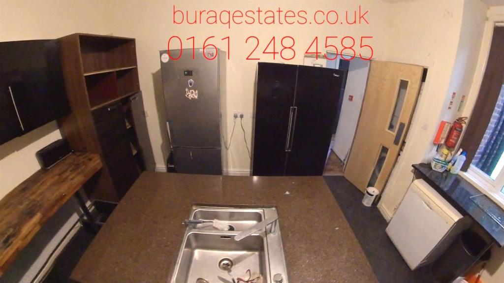 A modern kitchen with dark cabinetry, a stainle...