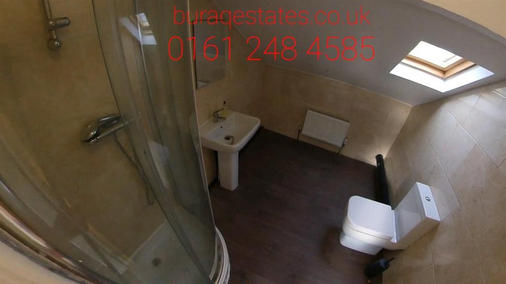 A modern bathroom featuring a curved glass show...