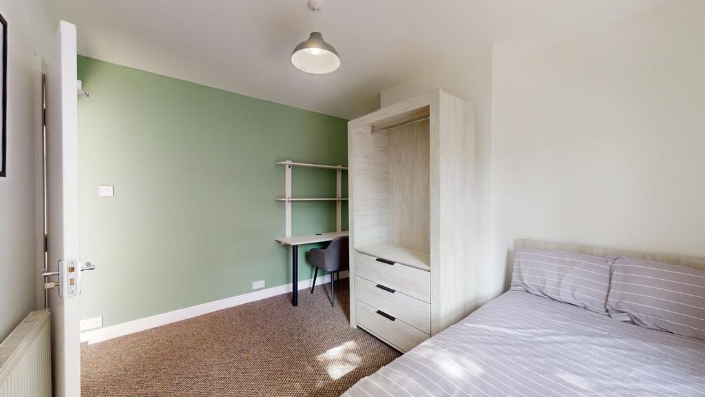 A bright and tidy double bedroom featuring a co...