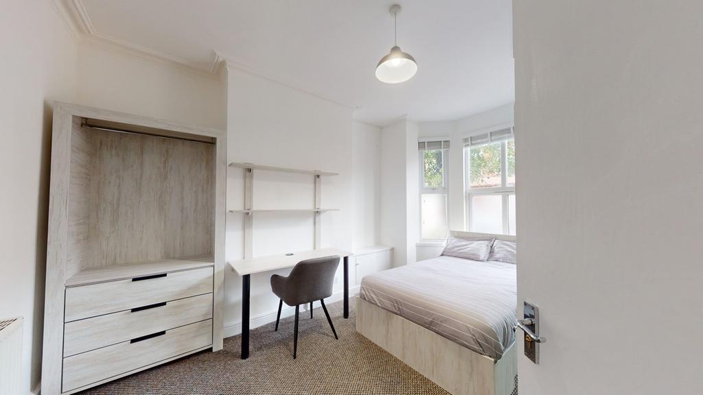A spacious and bright double bedroom featuring ...