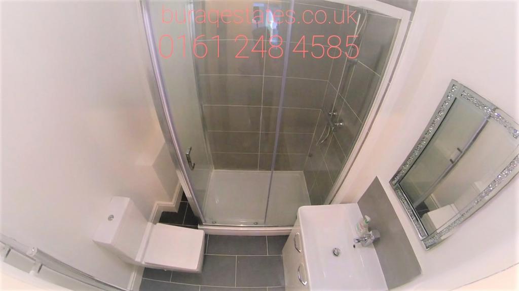 A modern bathroom suite featuring a glass-enclo...