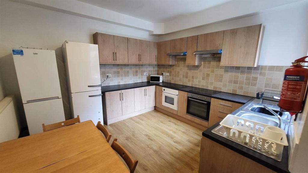 Bright and tidy kitchen featuring wooden cabine...