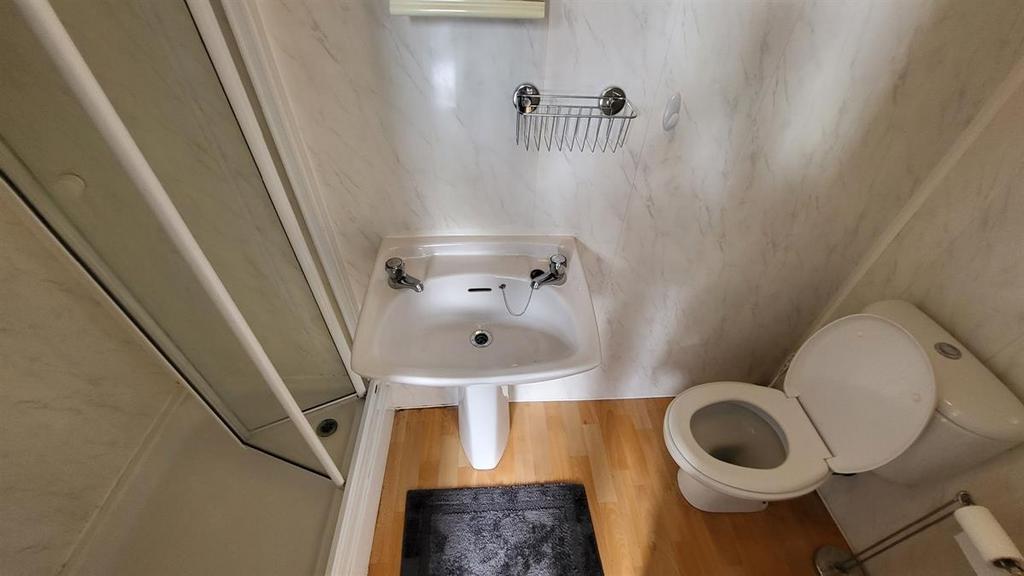 A compact bathroom featuring a white sink, toil...